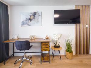 un bureau avec un bureau et une chaise dans l'établissement ImmoStay- Neustadt Apartments, TV & WiFi, à Brême