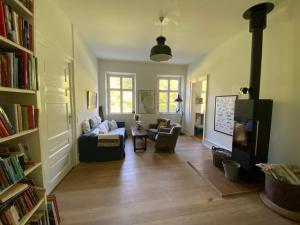 a living room with a couch and a tv at The Old Parsonage in Søndersø