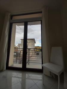 a room with a window with a chair and a balcony at La Casa di Leo in Stabbia