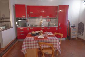 a kitchen with a table and chairs and red cabinets at Casa Roberto in Castelnuovo di Porto +6 photos