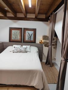 a bedroom with a white bed with two pictures on the wall at Lebari in Bérriz