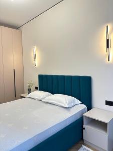 Bett mit blauem Kopfteil in einem Zimmer in der Unterkunft Уютная и светлая квартира в Алматы рядом с метро in Almaty
