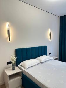Bett mit blauem Kopfteil in einem Schlafzimmer in der Unterkunft Уютная и светлая квартира в Алматы рядом с метро in Almaty