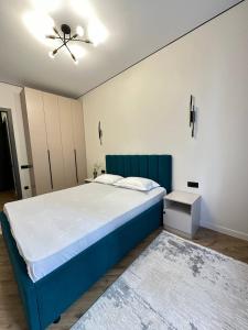 Schlafzimmer mit einem blauen Bett und einem Deckenventilator in der Unterkunft Уютная и светлая квартира в Алматы рядом с метро in Almaty + 10 Fotos