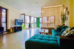 a living room with a blue couch and a tv at Plaza di Drama in Drama