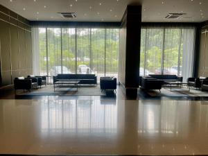 a lobby with chairs and tables and large windows at Opus Residences KL by SA in Kuala Lumpur +128 photos