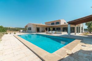 a swimming pool in front of a house at Villa Olivo in Ses Salines