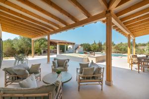a patio with chairs and a table and a pool at Villa Olivo in Ses Salines