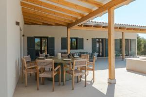 an outdoor dining area with a table and chairs at Villa Olivo in Ses Salines