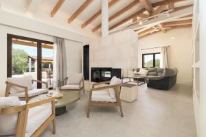 a living room with white furniture and a fireplace at Villa Olivo in Ses Salines