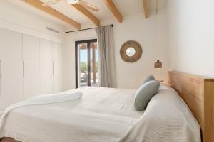 a white bedroom with a bed and a mirror at Villa Olivo in Ses Salines +42 photos