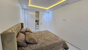 a bedroom with a bed and a couch with pillows at Tanger Luxury 4BR with AC WiFi and Beach Access in Tangier