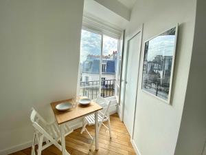 a small apartment with a table and chairs and a balcony at New 466 Suite Alain - Cosy Apartment Paris Center in Paris