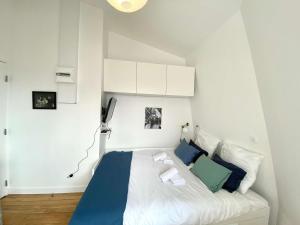 a bedroom with a bed with blue and green pillows at New 466 Suite Alain - Cosy Apartment Paris Center in Paris