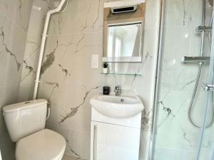 a bathroom with a toilet and a sink and a shower at New 466 Suite Alain - Cosy Apartment Paris Center in Paris +7 photos