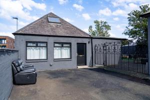 a house with a chair in front of a gate at Elegant 1BD, Gym, Parking, Bus to Airport, Sleeps4 in Edinburgh