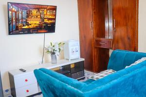 Una sala de estar con un sofá azul y una mesa. en Little escalade, en Mombasa