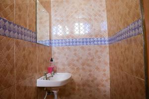 un baño con lavabo y espejo en Little escalade, en Mombasa