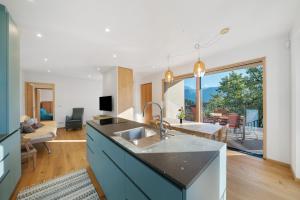 une cuisine avec un évier et un salon dans l'établissement Apartment Plattwies, à Vollan