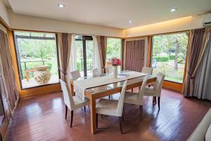 ein Esszimmer mit Tisch und Stühlen und Fenstern in der Unterkunft The Langit Duyong Marina Resort in Kuala Terengganu