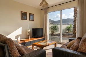 a living room with a couch and a television at Gonçalves Guest House Patio and Sea View in Porto Santo
