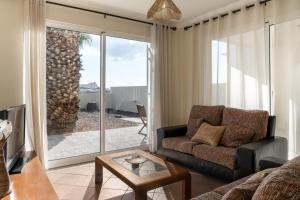 a living room with a couch and a view of the ocean at Gonçalves Guest House Patio and Sea View in Porto Santo