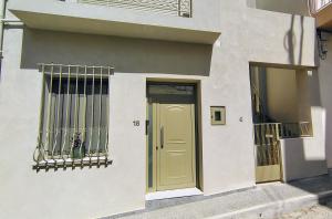 a building with a yellow door and a window at Kleopatra's residence in Bendevís