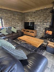 a living room with leather furniture and a fireplace at Aghavannagh Mountain Lodge in Aghavannagh