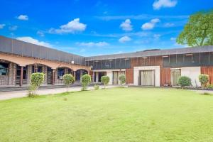 a building with a grass yard in front of it at Mayur Resort in Mathura