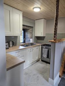 a kitchen with white cabinets and a sink at Aghavannagh Mountain Lodge in Aghavannagh +25 photos