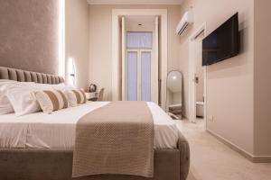 ナポリにあるMadame Toledo Luxury Roomsの大きなベッドと薄型テレビのある寝室