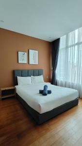 a bedroom with a large bed with a blue towel on it at Sky Suites KLCC Luxury Homestay in Kuala Lumpur