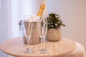 ナポリにあるMadame Toledo Luxury Roomsの鉢植えの植物が置かれた木製のテーブルの上にワイングラスが2つ +64枚の写真