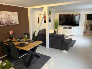 a living room with a table and a couch and a television at Best Preis Ferienhaus max 4 Personen Wittenberge Modernes Ambiente voll ausgestattet mit Netflix und WLAN in Wittenberge