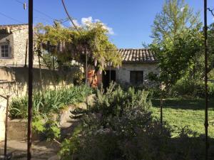 a garden in front of a stone house at Un Mazet en famille dans le jardin in Saint-Hippolyte-du-Fort