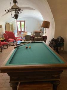 a pool table with balls on it in a living room at Un Mazet en famille dans le jardin in Saint-Hippolyte-du-Fort