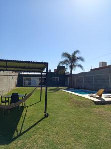 a hammock in the grass next to a swimming pool at Hospedaje Atardeceres in San Fernando del Valle de Catamarca