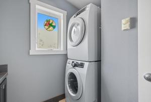 バンクーバーにあるModern Upper Level Duplex Dt Vancouverのキッチン(洗濯機付)、窓が備わります。