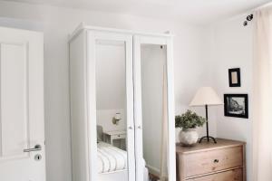 a white cabinet with a mirror in a room at Lillebror Skandinavische Ruhe mit privater Sauna in Baden-Baden