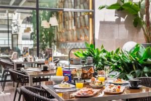 a table with plates of food on it in a restaurant at Hotel Barcelona Catedral 4 Sup in Barcelona +82 photos