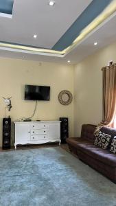 un salon avec un canapé et une télévision à écran plat dans l'établissement Shanum homestay, à Diyeng