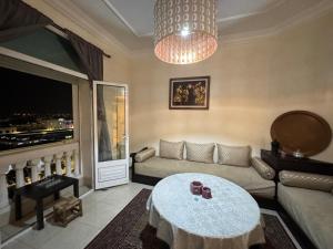 ein Wohnzimmer mit Sofa und Tisch in der Unterkunft Apartement Bab lhad in Rabat