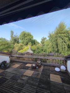 a porch with a wooden fence and trees at Ferienwohnung auf dem Land in Molzbach in Hünfeld