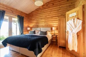 a bedroom with a bed in a log cabin at Alborada in Constable Burton