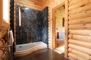 a bathroom with a shower and a tub in a log cabin at Alborada in Constable Burton +18 photos