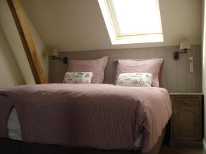 a bedroom with a pink bed with pillows and a window at Ferienhaus mit gemeinsamem Pool und Garten in Jabbeke +7 photos