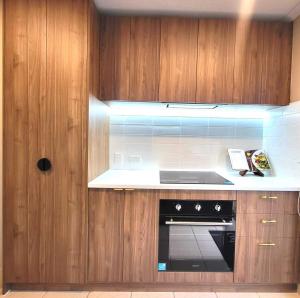 a kitchen with wooden cabinets and a stove top oven at Private Room 2- Affordable Luxury in Craigieburn