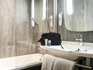 a bathroom with a sink and a shower and a toilet at ibis Bordeaux Centre Gare Saint Jean Euratlantique in Bordeaux +59 photos