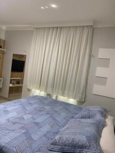 a bedroom with a bed in front of a window at Seller House II in Sobral