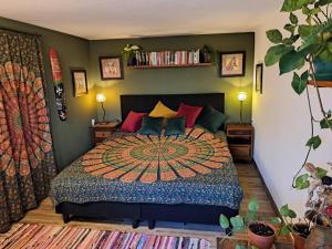 a bedroom with a large bed with a colorfulspread at This Old House in Ponta do Pargo